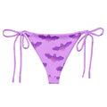 Aensland String Bikini Bottom in playful purple bat print, perfect for sunbathing by the pool this summer.