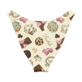 Royal Cookie V-cut bikini bottom featuring a whimsical pattern of chocolates and crowns in soft colors.