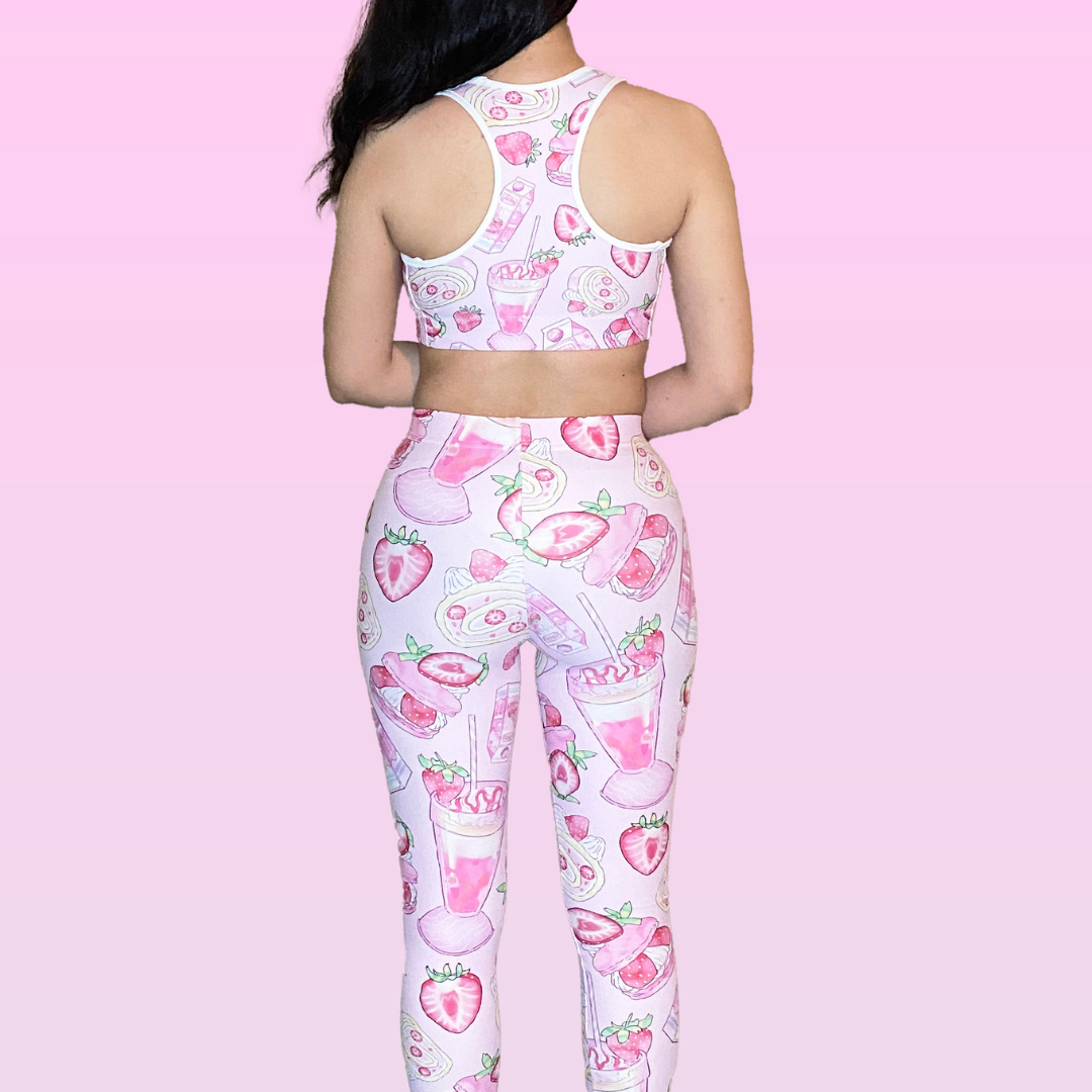 Woman wearing Strawberry Leggings with a fun print, showcasing her stylish look from the back against a pink background.