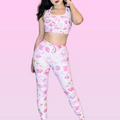 Fun and stylish strawberry leggings with matching crop top on model against a pink pastel background.